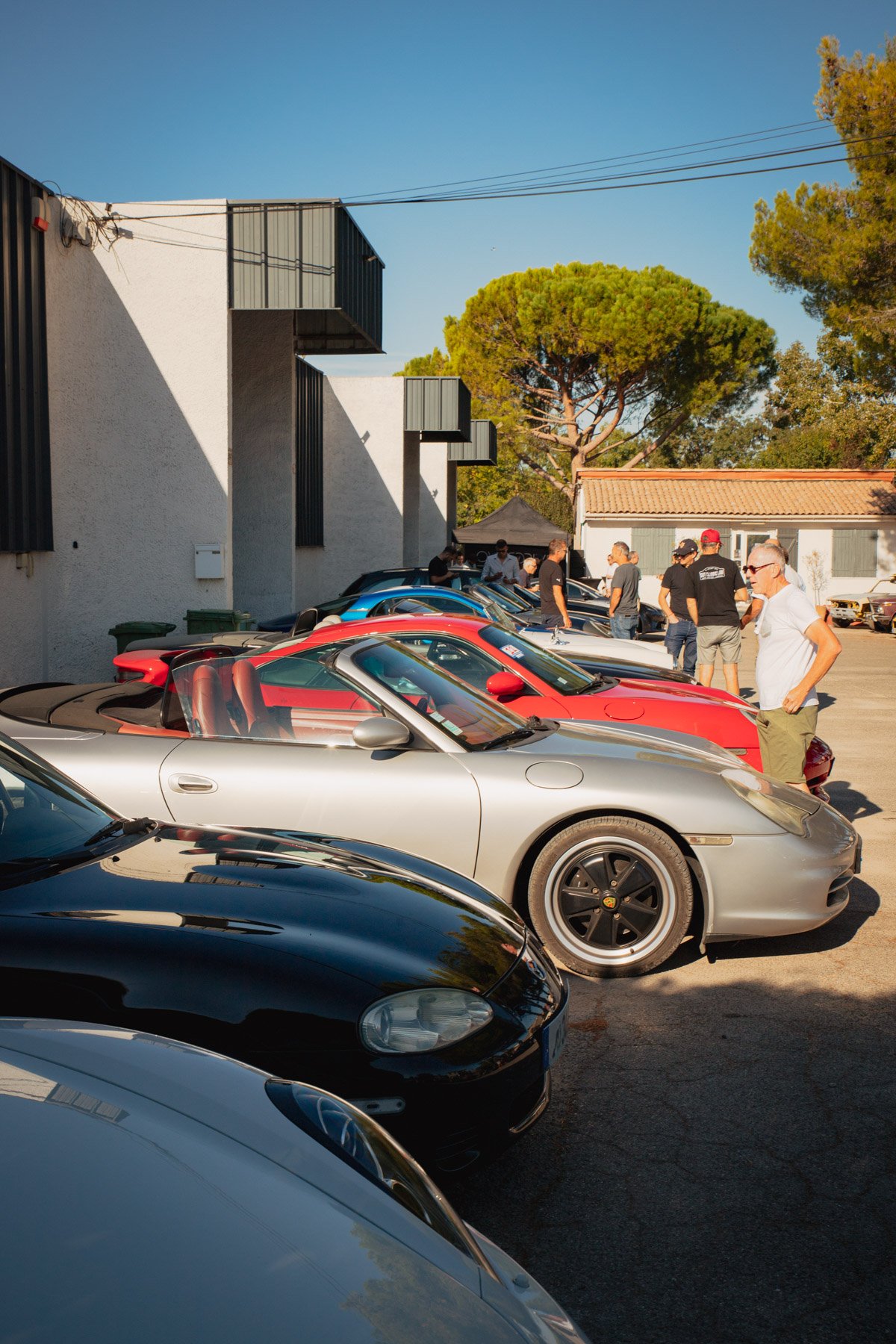 Porsche 911 cabriolet argentée avec intérieur rouge lors du rassemblement Bolides & Brioches.