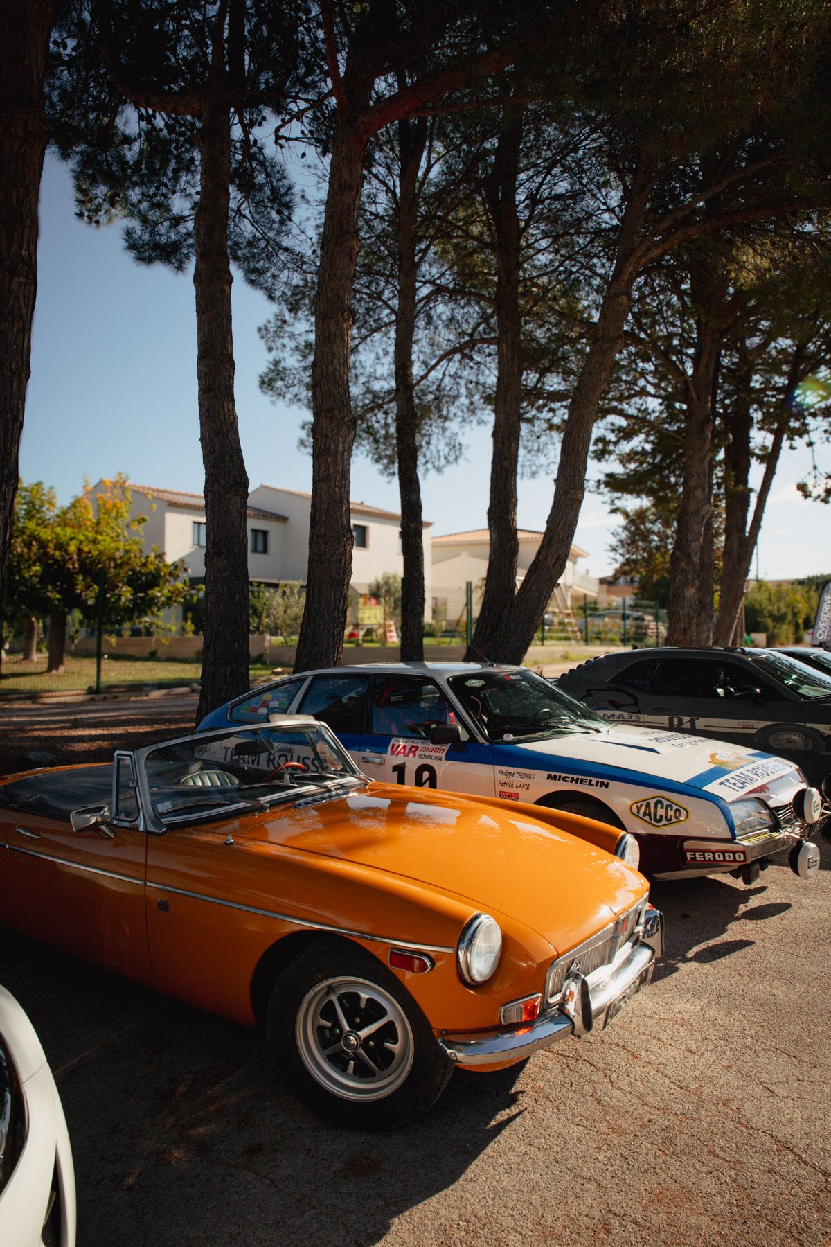 MG B orange et voiture de rallye historique lors de Bolides & Brioches à Venelles.