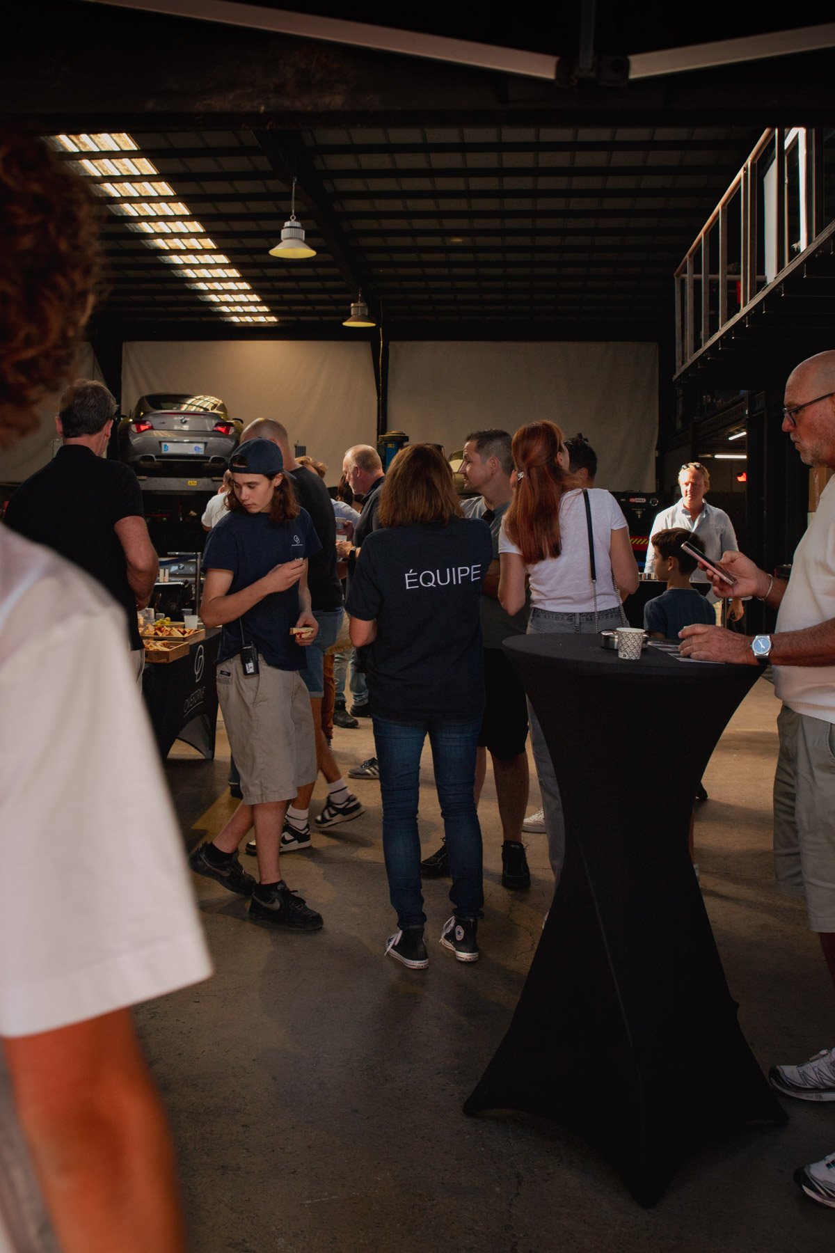 Ambiance conviviale dans l’atelier d’Overdrive Automobile pendant Bolides & Brioches