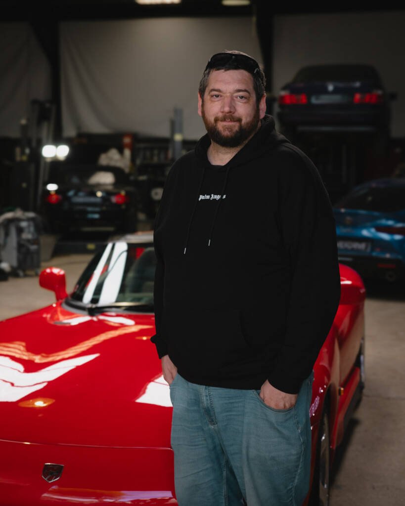 Nicolas, propriétaire depuis 22 ans d'une Chrysler Viper RT/10 rouge, photographié devant sa voiture.